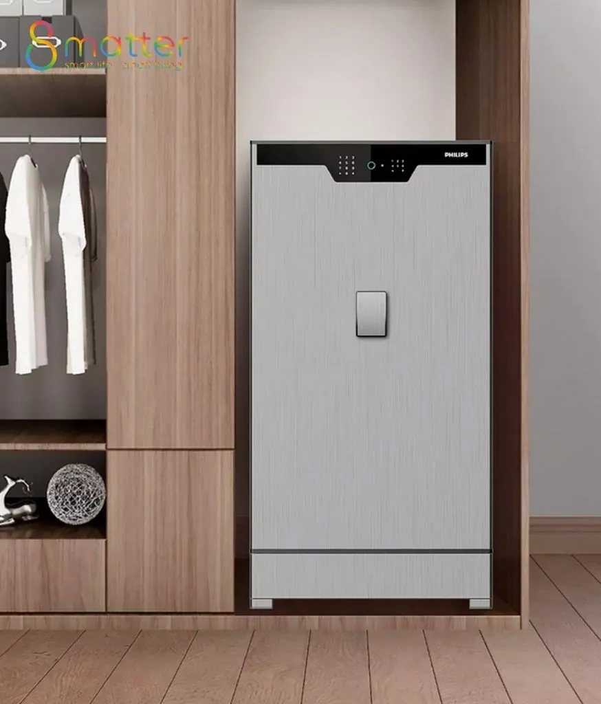 Két sắt Philips mặt bạc đặt trong hốc tủ quần áo gỗ bên cạnh áo treo