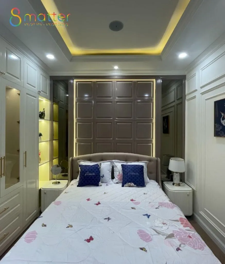 Phòng ngủ với ánh đèn vàng ấm từ đèn hắt trần vào buổi tối