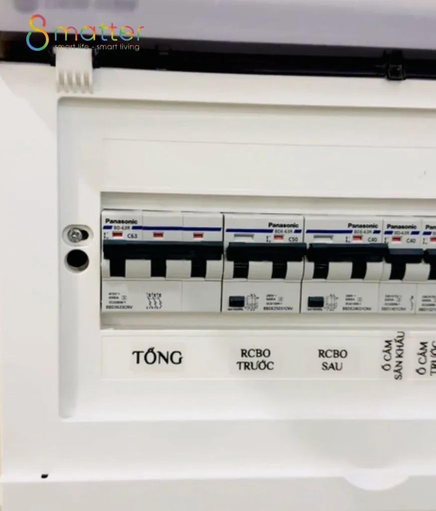 Tủ điện trắng mở nắp, dãy aptomat Panasonic có nhãn ghi từng lộ điện