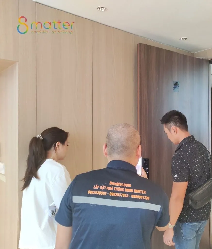 Ba người đứng trao đổi với nhau trong hành lang một căn hộ