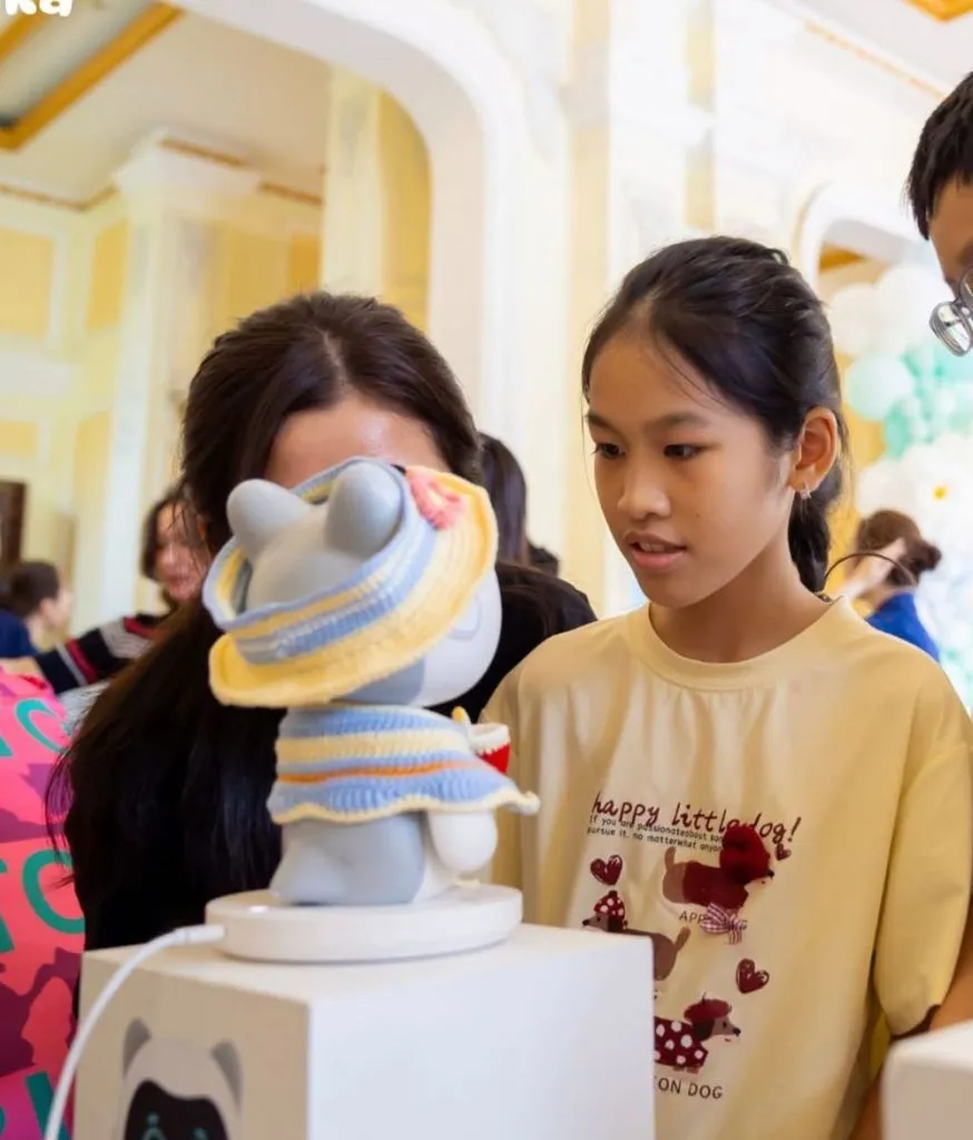 Ba robot Pika đặt trên bục, nhân viên đứng giới thiệu cho khách tham quan