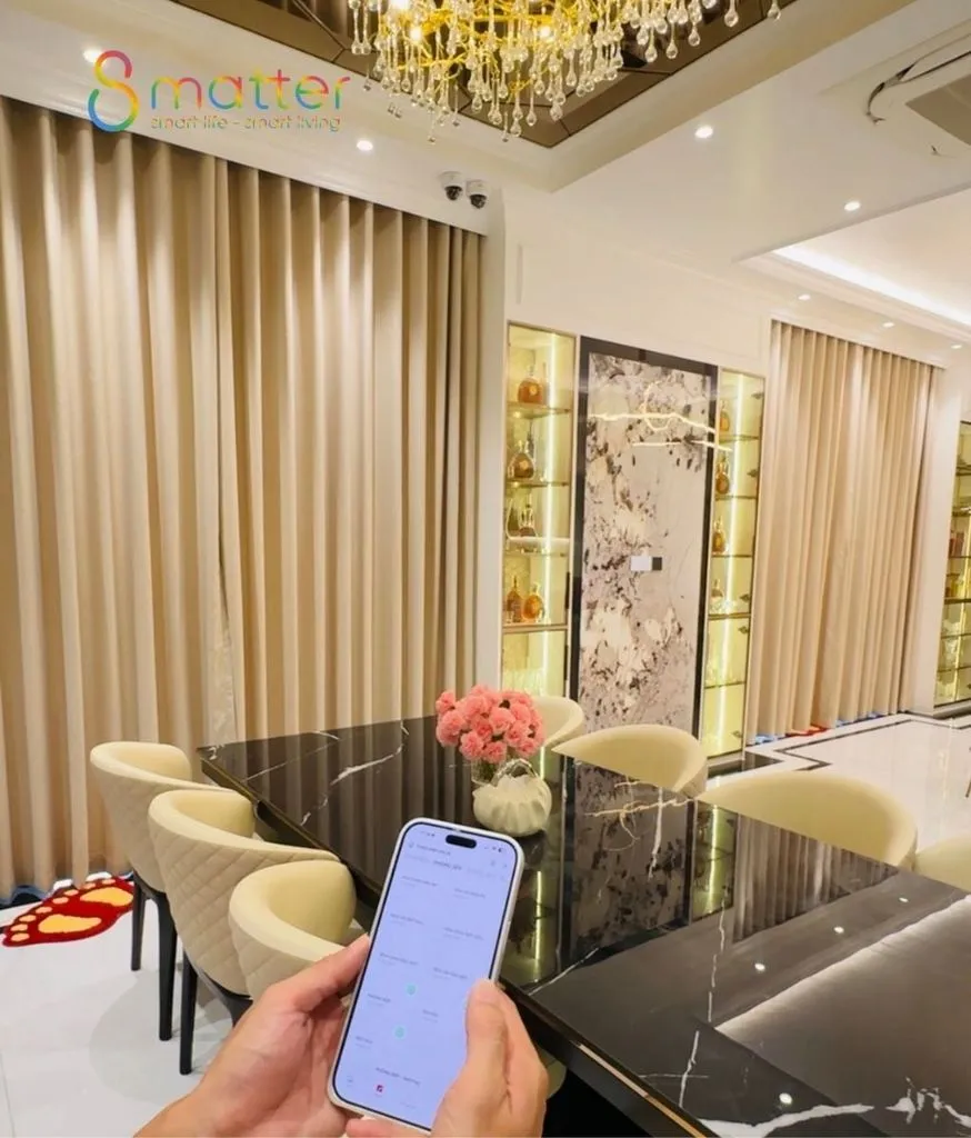 Bàn tay cầm chiếc điện thoại ở giữa một phòng ăn sang trọng