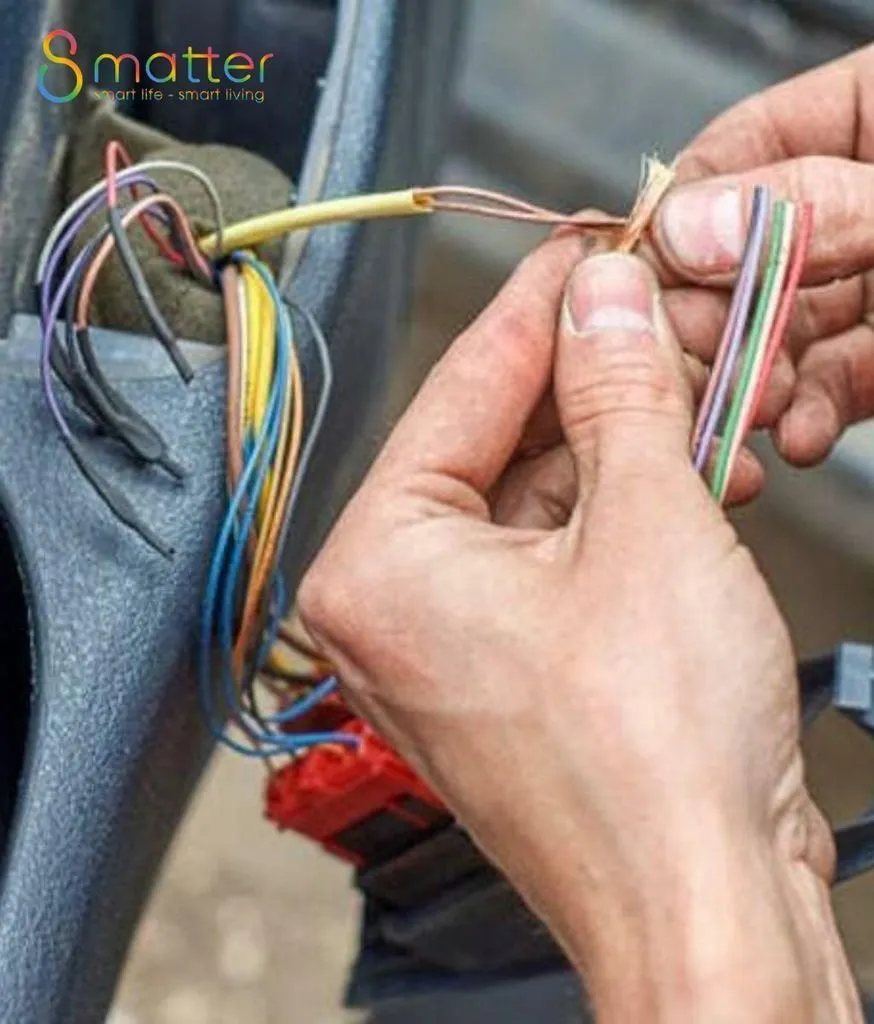 Bàn tay đang nối một bó dây điện gồm nhiều màu khác nhau