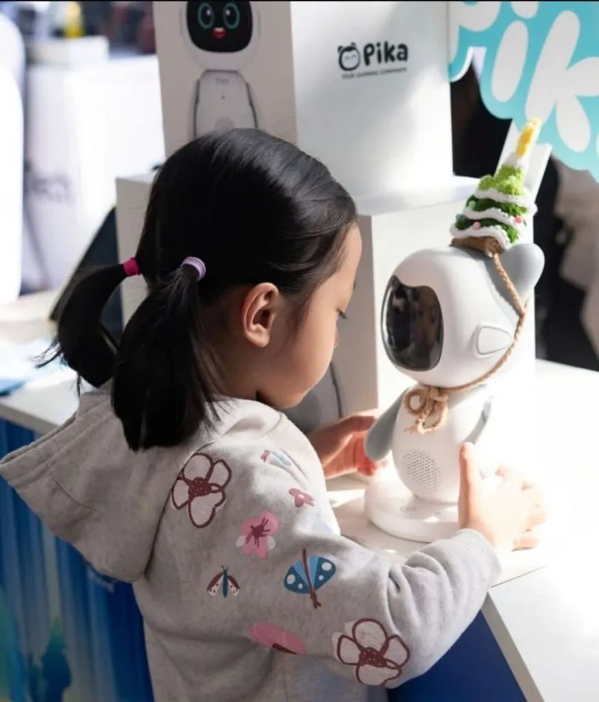 Bé gái đứng chạm tay vào robot Pika trên bục trưng bày tại showroom