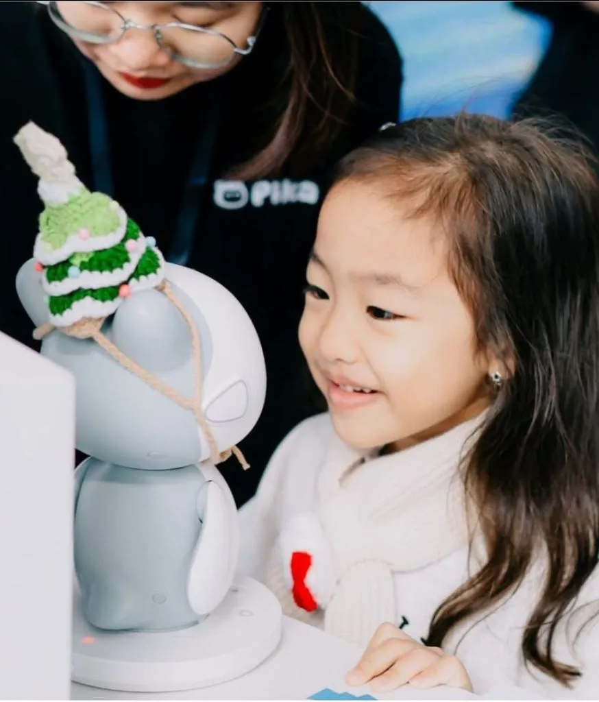 Bé gái ngồi cạnh robot Pika đội mũ len tại gian hàng 8matter Smart Home