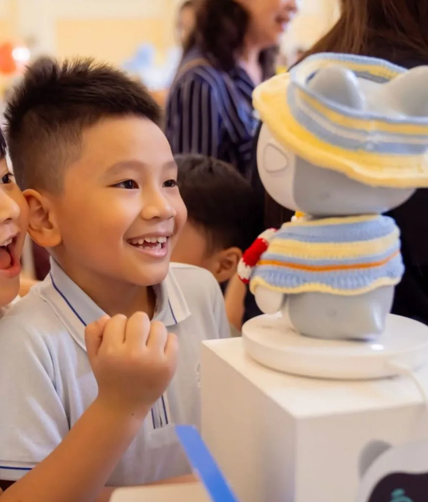 Bé trai đứng xem robot Pika được đặt trên bục trưng bày trong cửa hàng