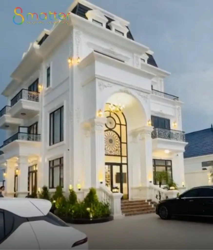 Biệt thự trắng tân cổ điển ba tầng lên đèn, hai ô tô đỗ trước sân
