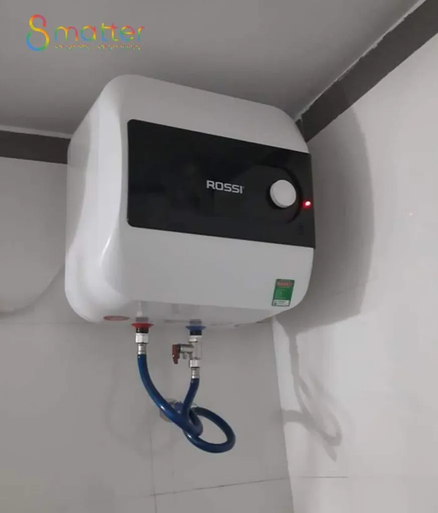 Bình nóng lạnh ROSSI trắng gắn góc tường, ống nước xanh và van đồng phía dưới