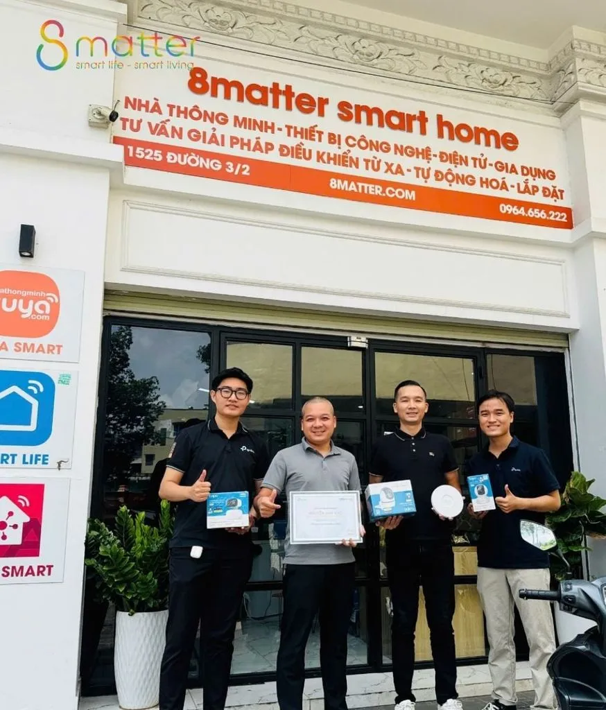 Bốn nhân viên mặc áo 8matter đứng trước cửa hàng, một người cầm hộp sản phẩm