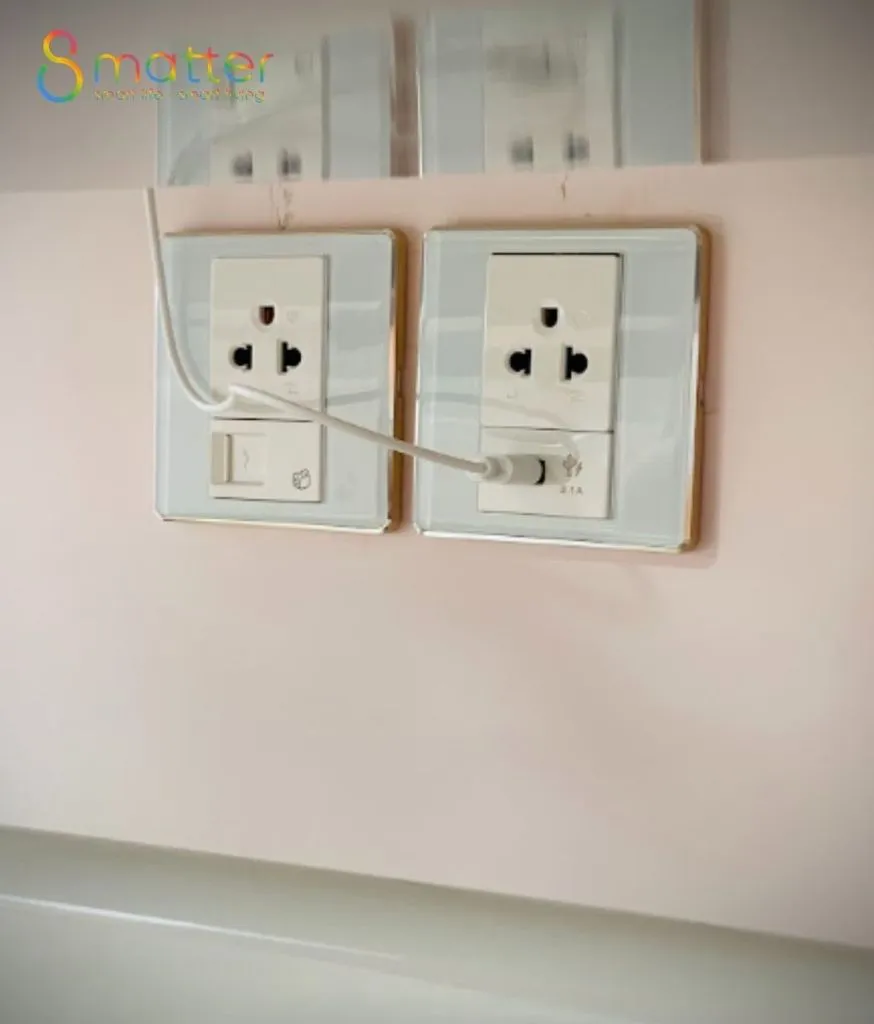 Hai mặt ổ cắm trắng có công tắc gắn trên tường hồng nhạt
