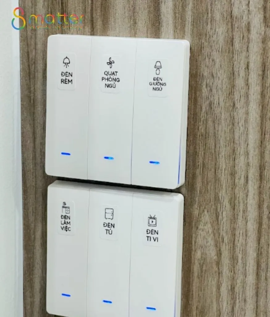 Hai bộ công tắc trắng ba nút dán nhãn gắn trên vách vân gỗ