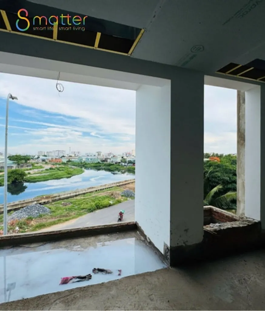 Công trình xây thô, cửa sổ lớn nhìn ra sông và khu dân cư