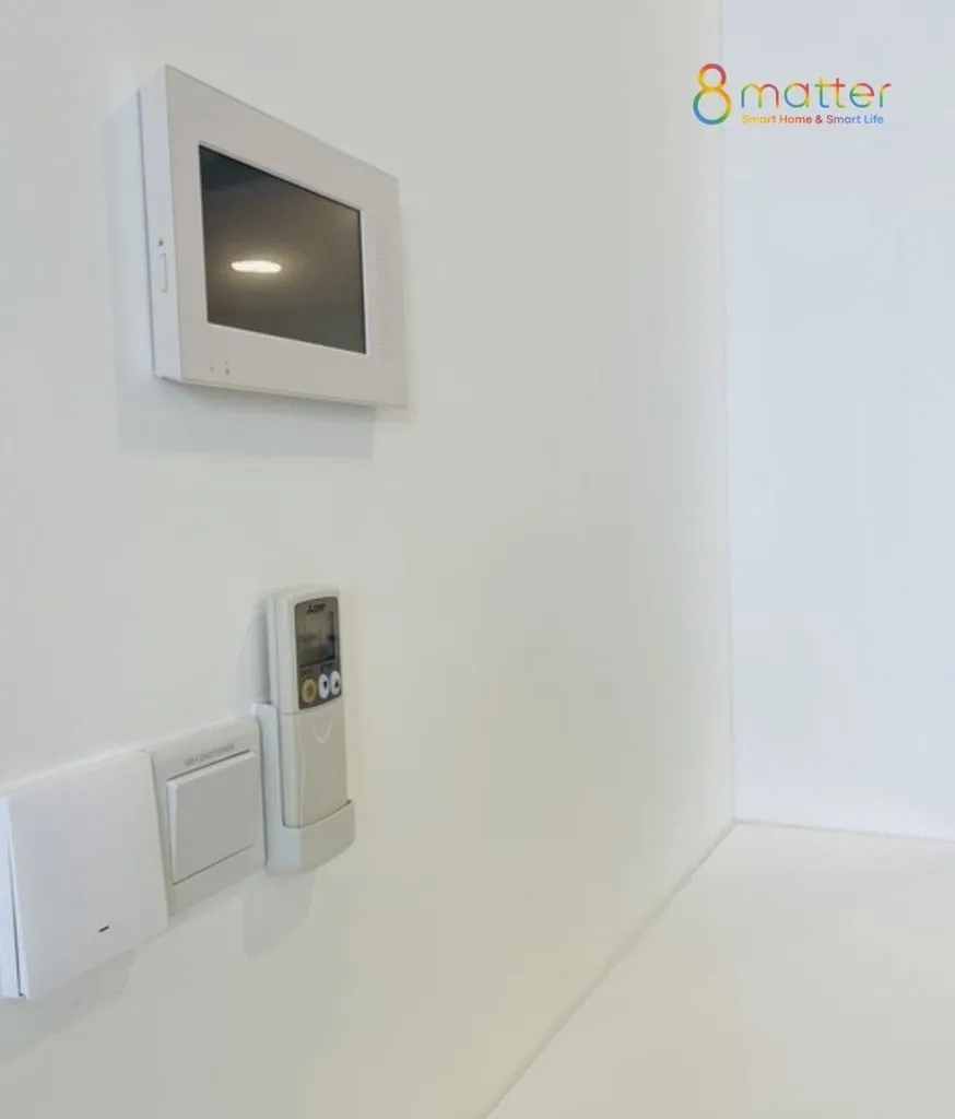 Tường trắng gắn hộp kỹ thuật, điều khiển điều hoà và một công tắc trắng