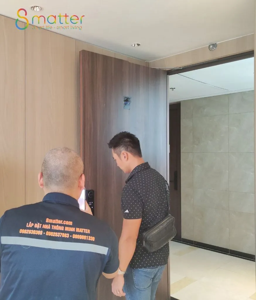 Hai kỹ thuật viên 8matter đứng trao đổi với nhau ở hành lang một căn hộ