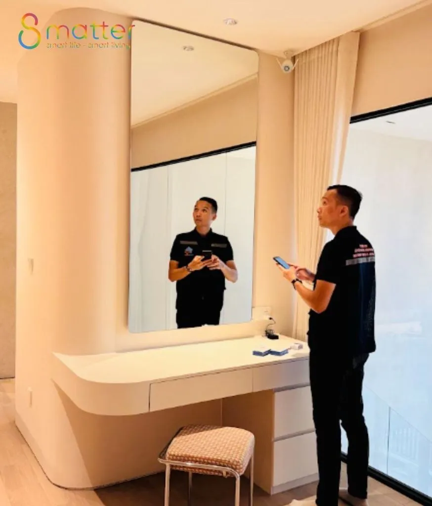 Hai người đứng nói chuyện trong căn phòng có bồn rửa gắn tường