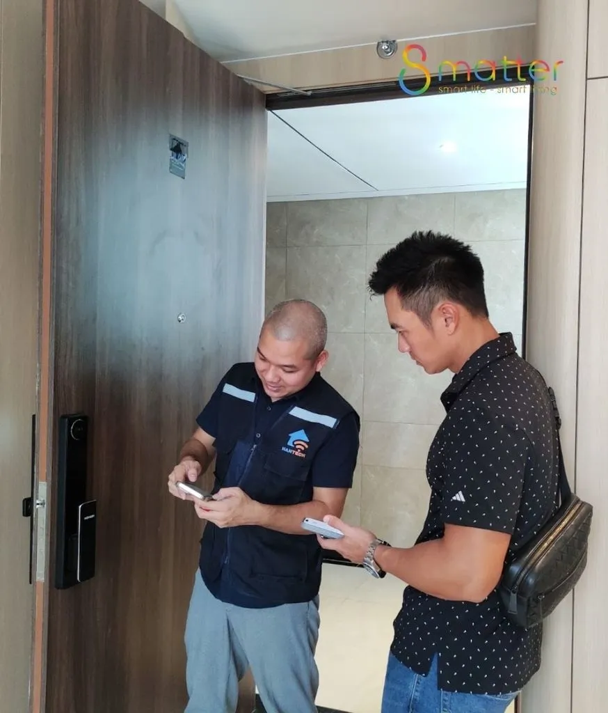 Hai người đứng trao đổi ngay cạnh cánh cửa trong hành lang