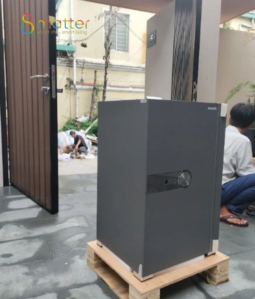 Két sắt cỡ lớn màu xám đặt trên pallet gỗ ngoài sân