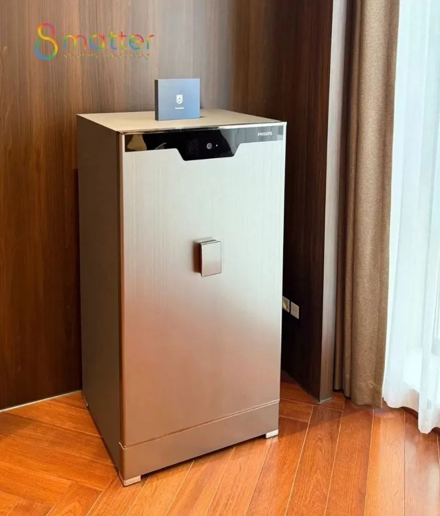 Chiếc két sắt màu kem đặt sát cạnh tấm rèm bên ô cửa sổ