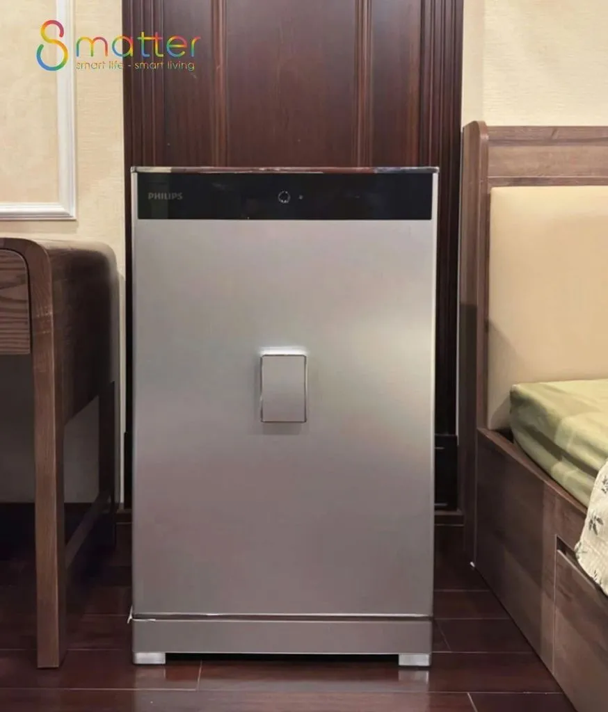 Két sắt màu bạc dáng cao đặt sát cạnh giường ngủ trong phòng