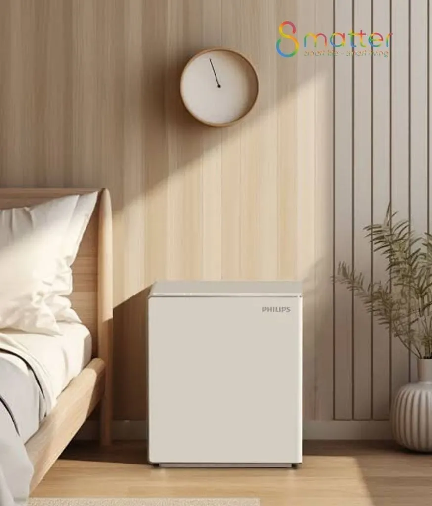Két sắt trắng kê cạnh giường, trên tường treo một chiếc đồng hồ