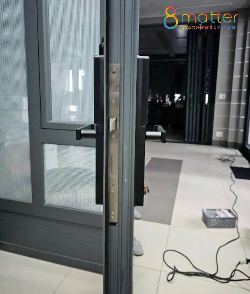 Cửa nhôm kính hai cánh gắn khoá, sàn nhà xưởng đang thi công dây điện