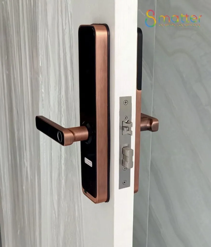 Khóa cửa màu nâu đồng lắp trên một cánh cửa gỗ sáng màu