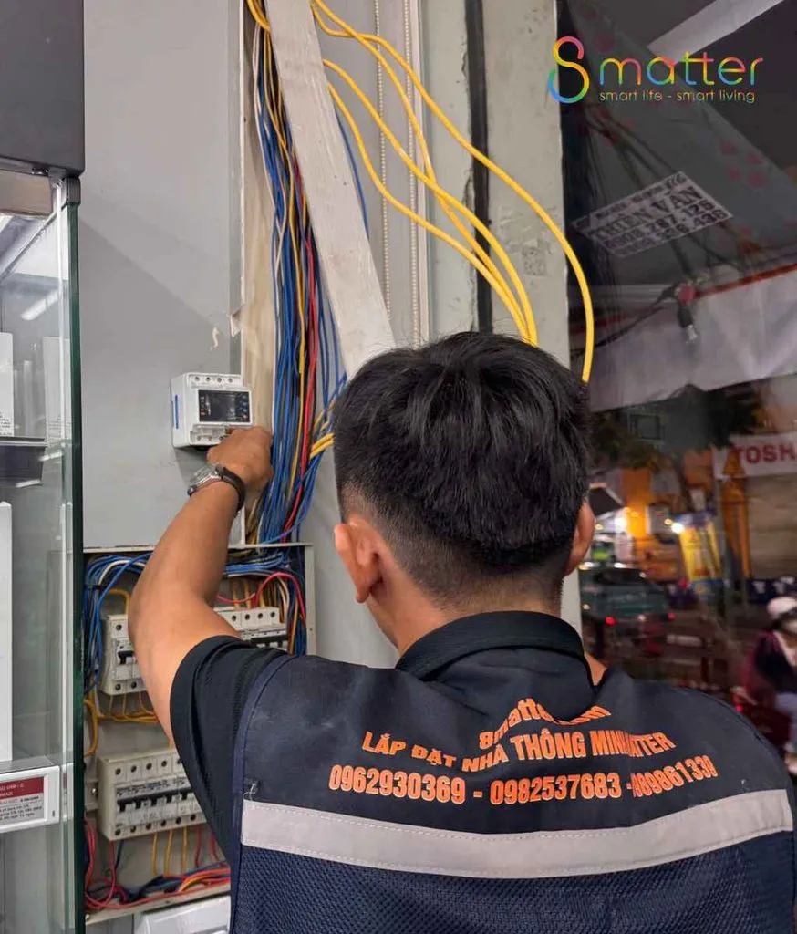 Kỹ thuật viên 8matter đang đấu nối các dây màu bên trong tủ điện