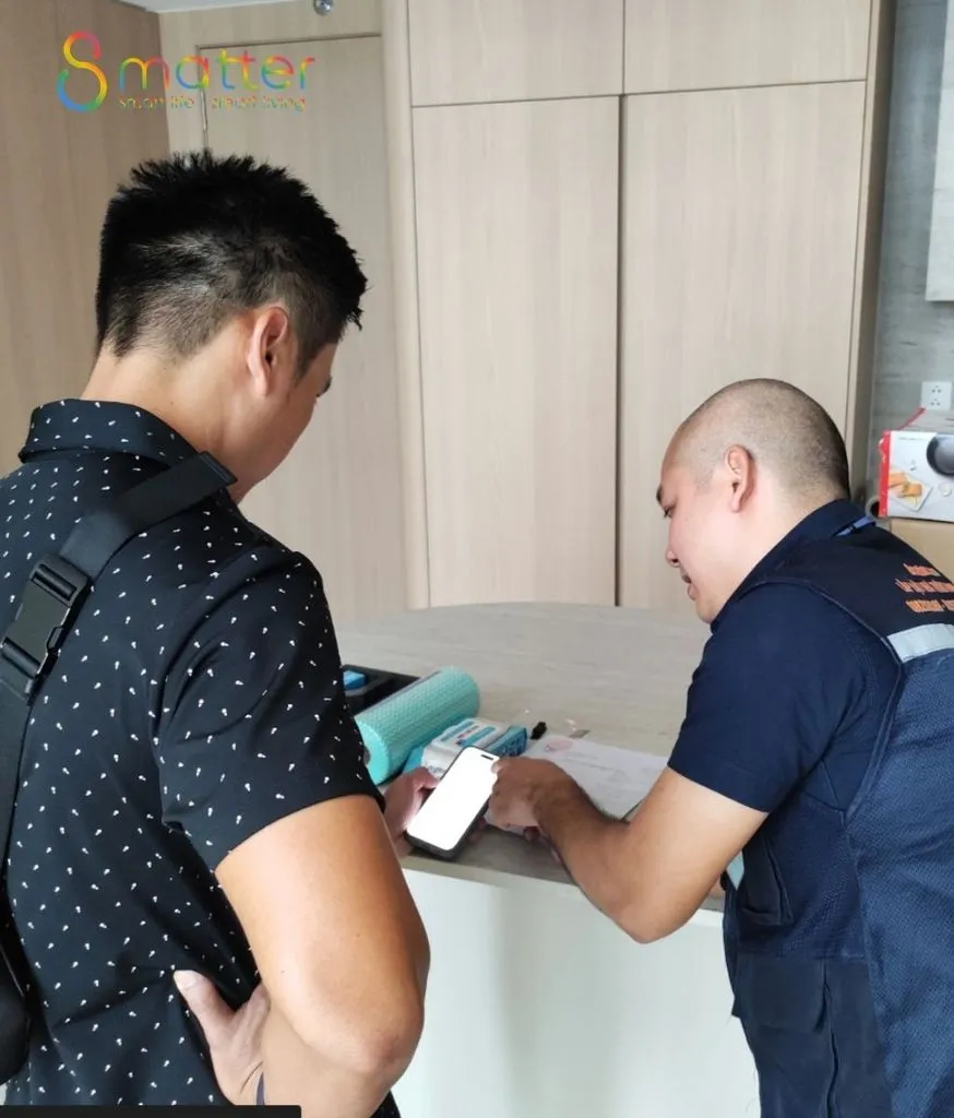 Kỹ thuật viên đang hướng dẫn khách dùng điện thoại để điều khiển thiết bị trong nhà