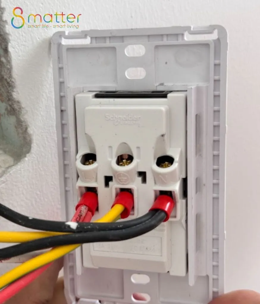 Mặt sau ổ cắm âm tường với dây đỏ, đen và vàng đã đấu vào cọc