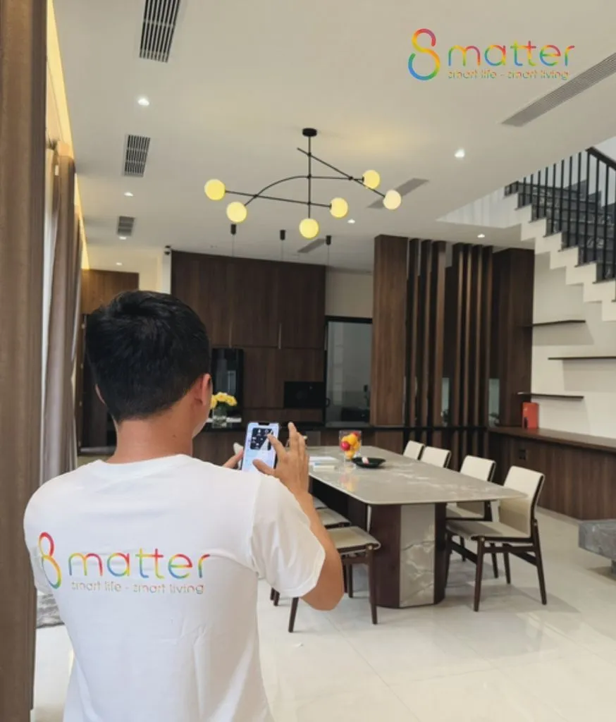 Nhân viên áo trắng in logo 8MATTER đứng chụp ảnh nghiệm thu phòng khách liền bếp