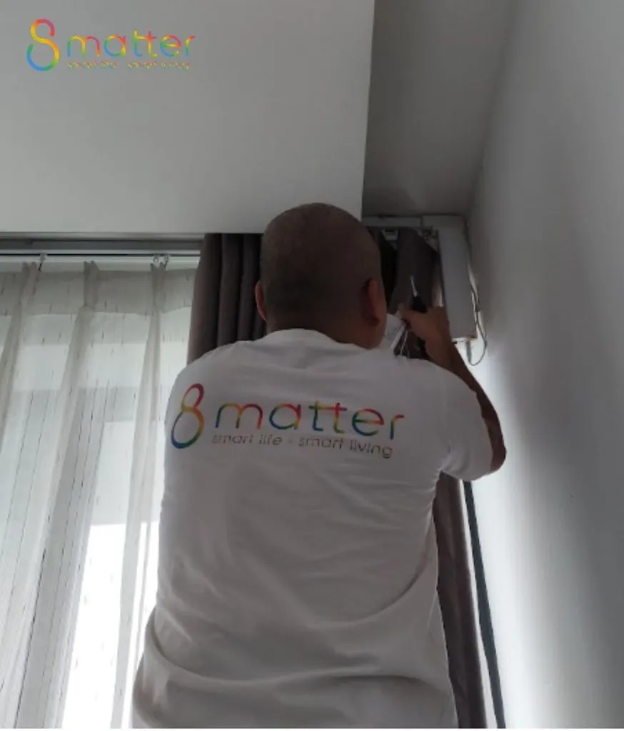 Người mặc áo in chữ 8matter đang cầm máy quay phim bên trong nhà