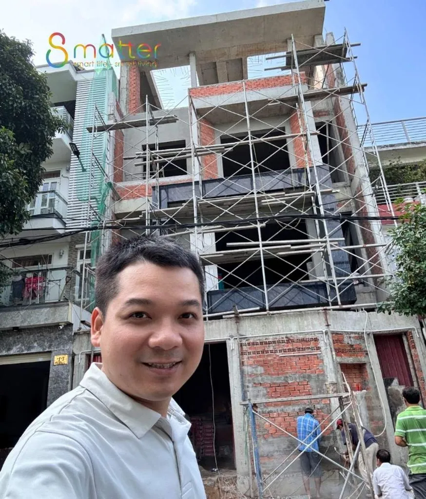 Nhân viên 8matter đứng trước ngôi nhà đang xây có giàn giáo