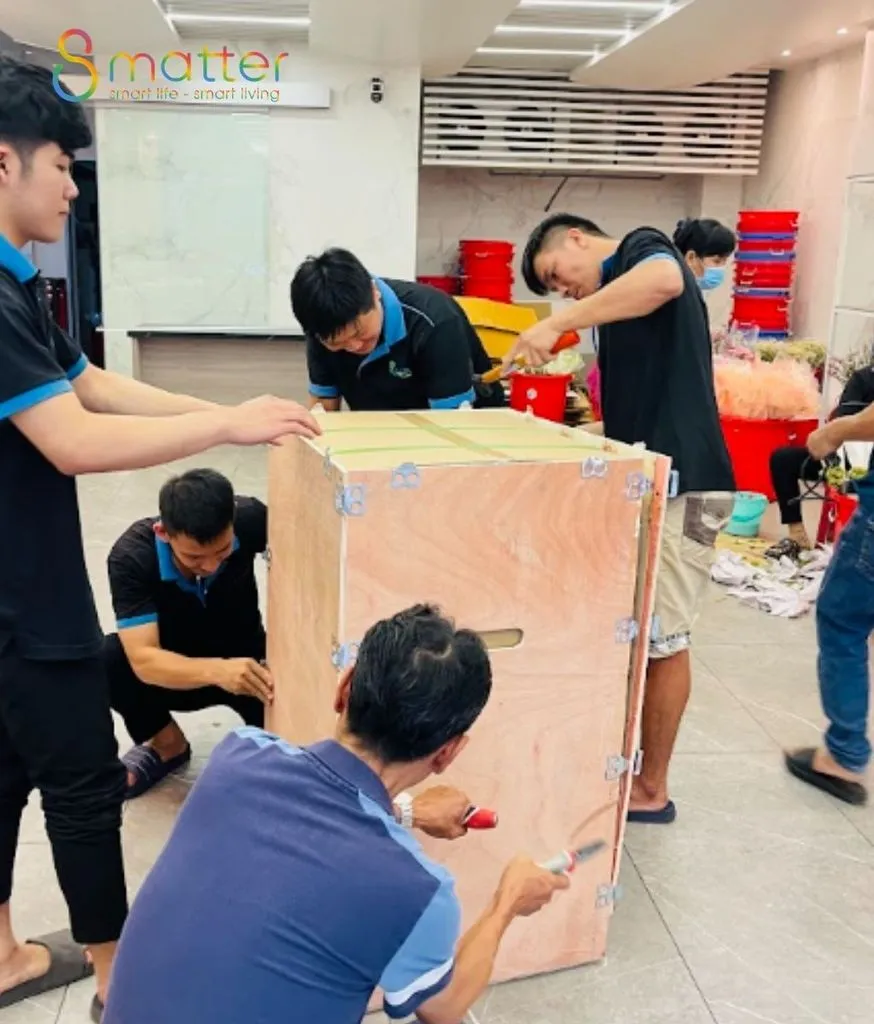 Nhóm nhân viên đang đóng thùng gỗ bảo vệ két sắt ngay trong kho hàng