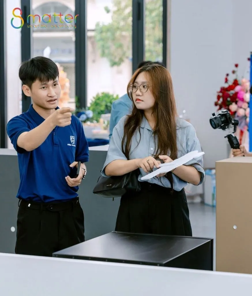 Một nhân viên nam và một nhân viên nữ trao đổi ngay trước cửa hàng