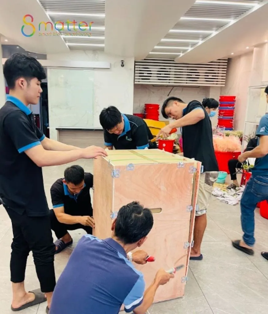 Nhóm nhân viên đang đóng gói một chiếc két sắt ngay trong cửa hàng