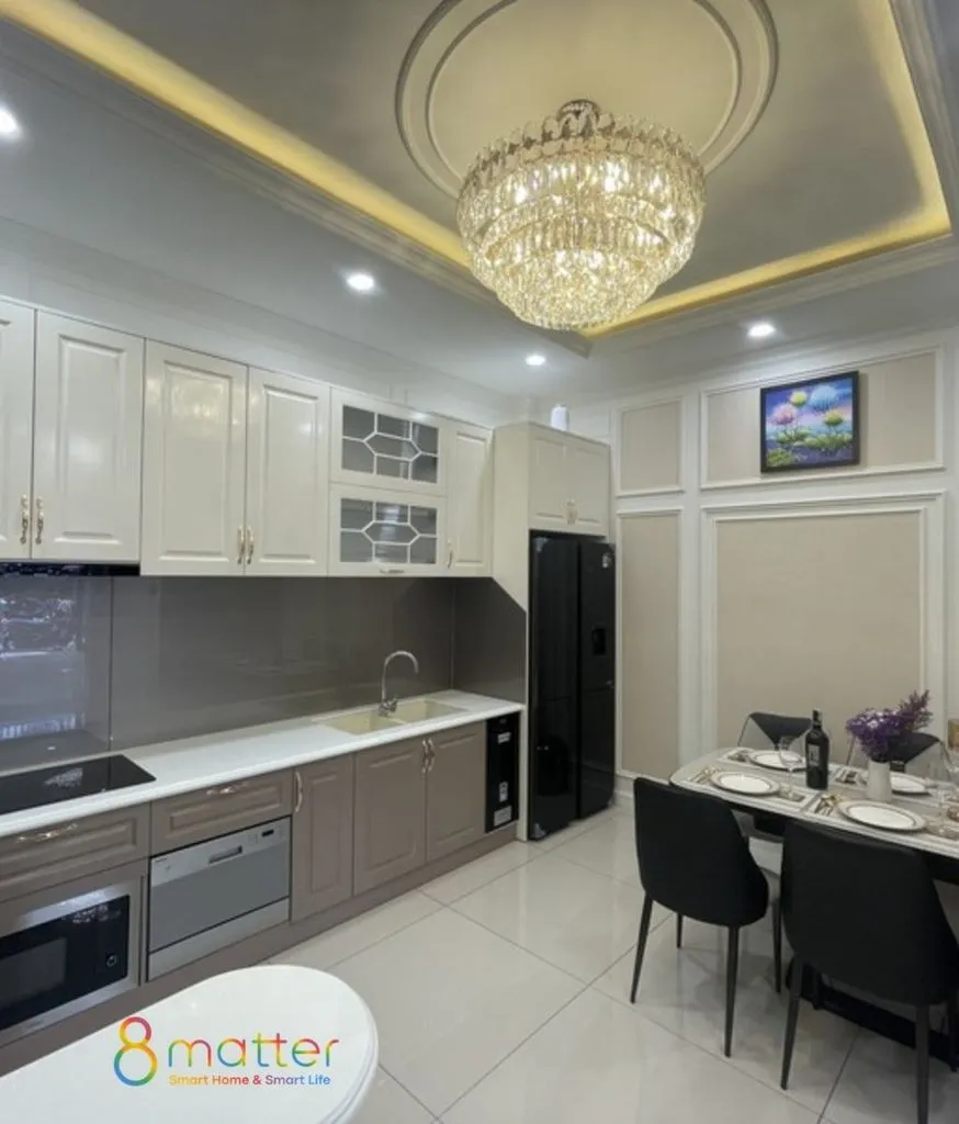 Bếp tân cổ điển màu kem với đèn chùm pha lê và bàn ăn bốn ghế