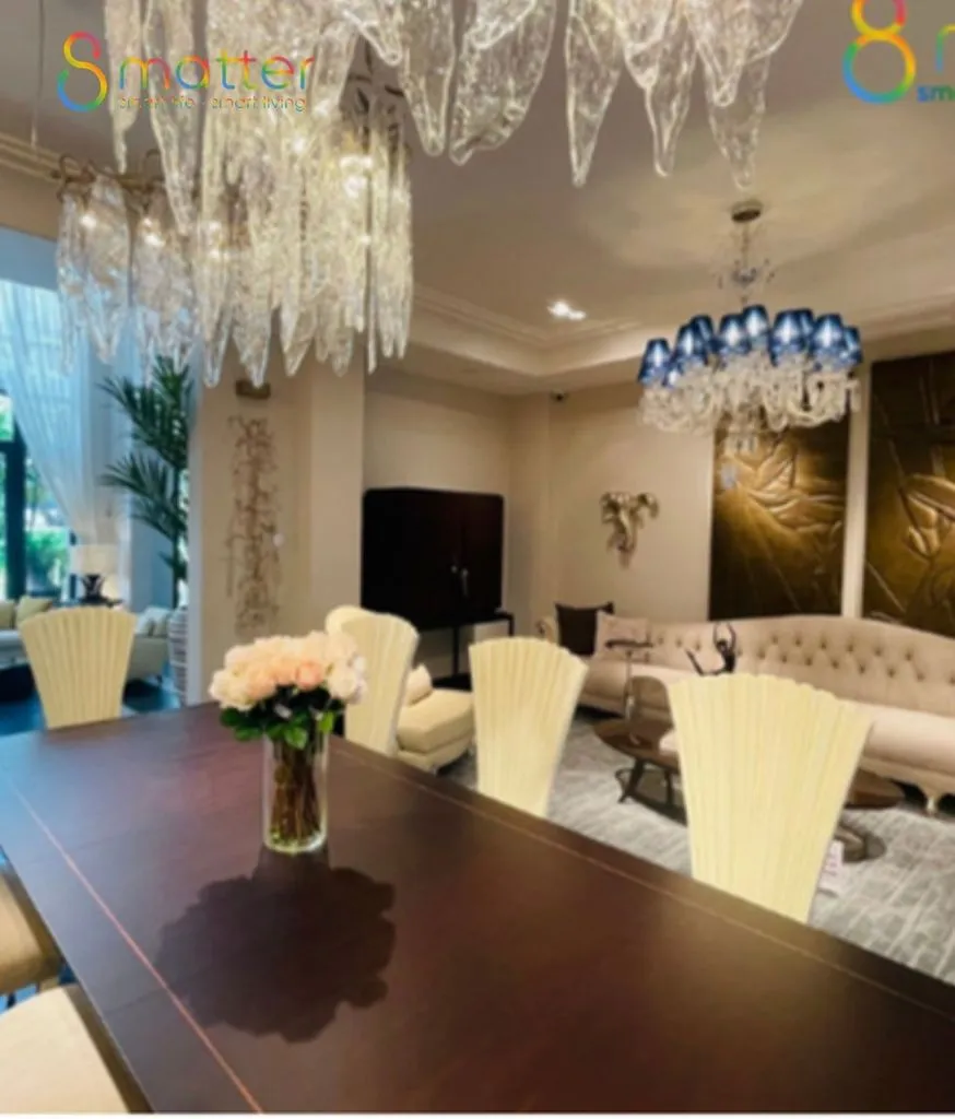 Phòng ăn sang trọng, bàn gỗ dài, đèn chùm pha lê lớn, bình hoa trắng