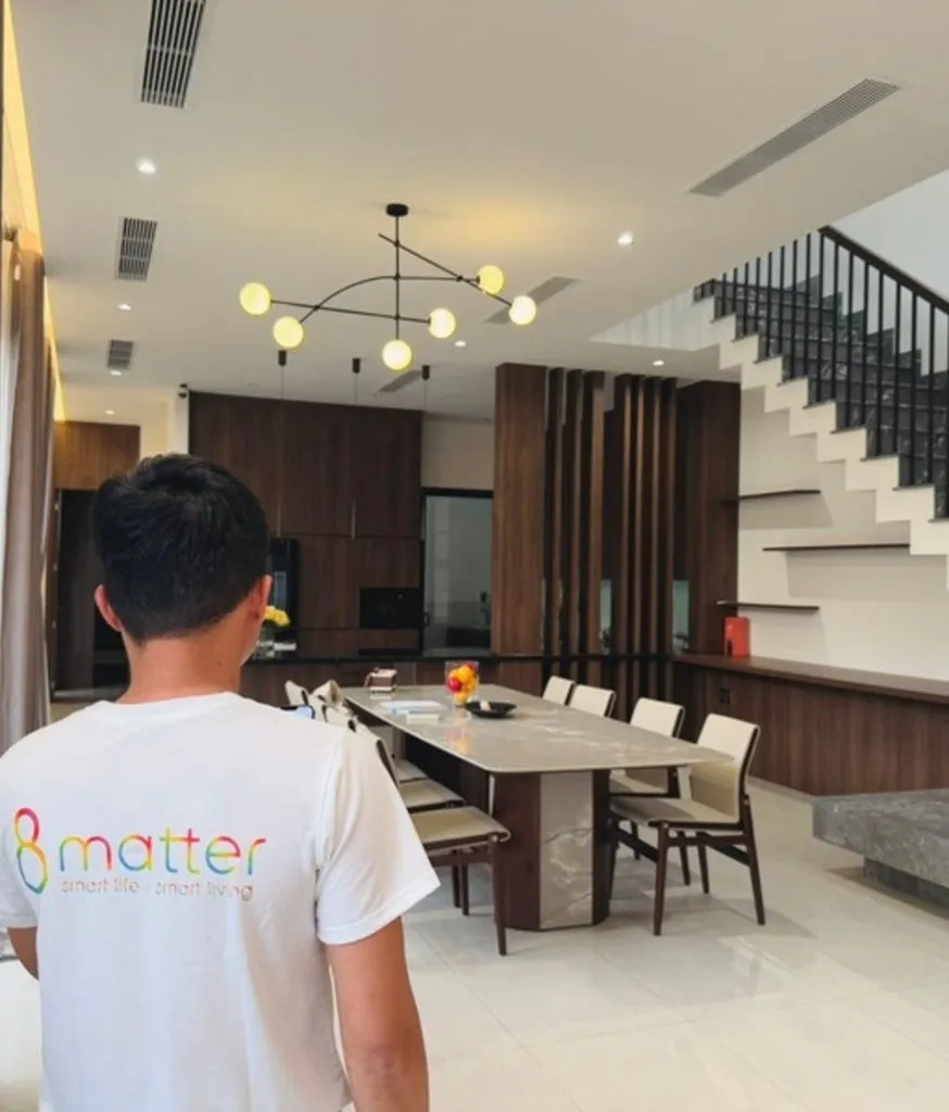 Nhân viên áo 8matter đứng trong phòng ăn rộng có cầu thang phía sau