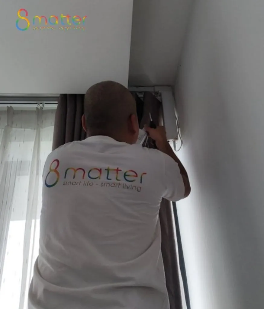 Kỹ thuật viên áo trắng in logo 8matter đứng lắp thanh ray rèm trên trần