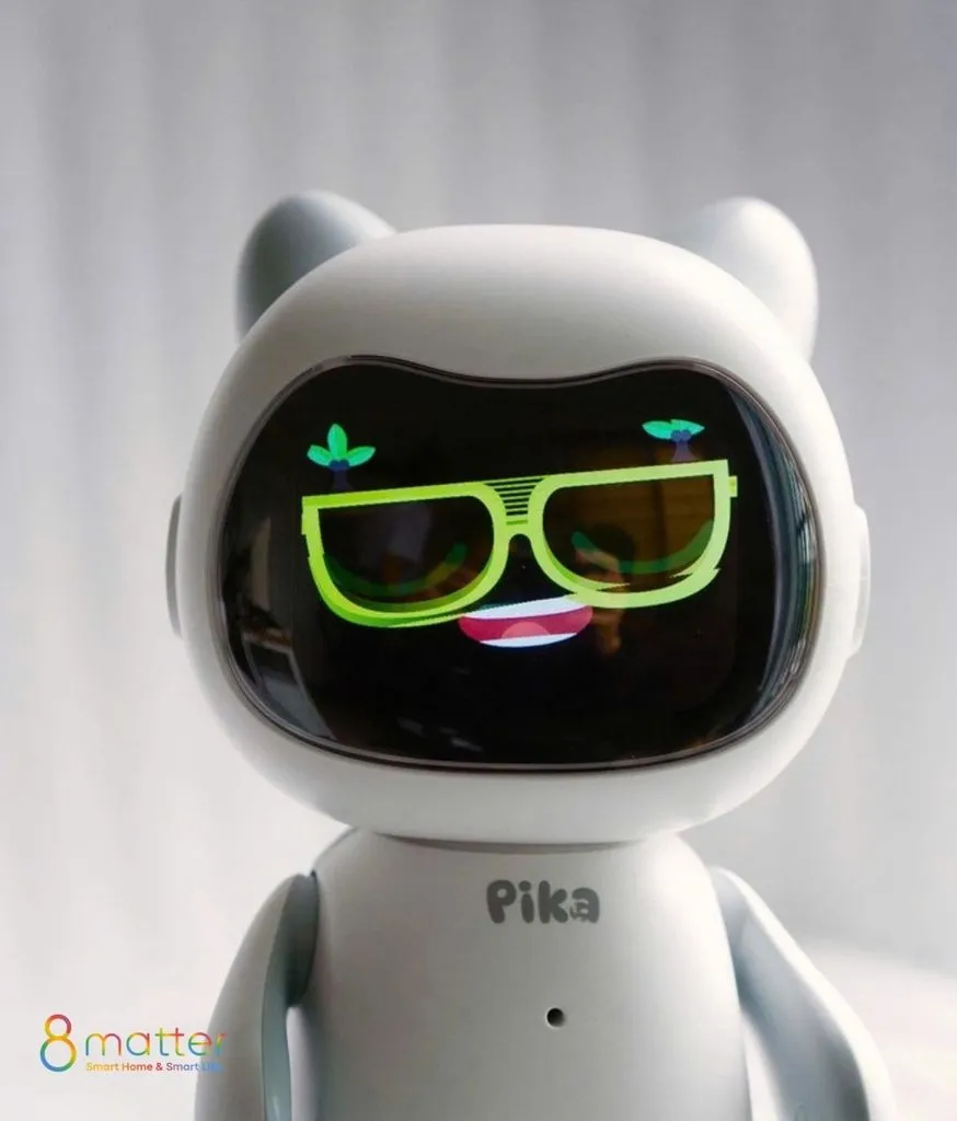 Cận cảnh robot Pika màu trắng, màn hình mặt hiển thị biểu cảm vui vẻ