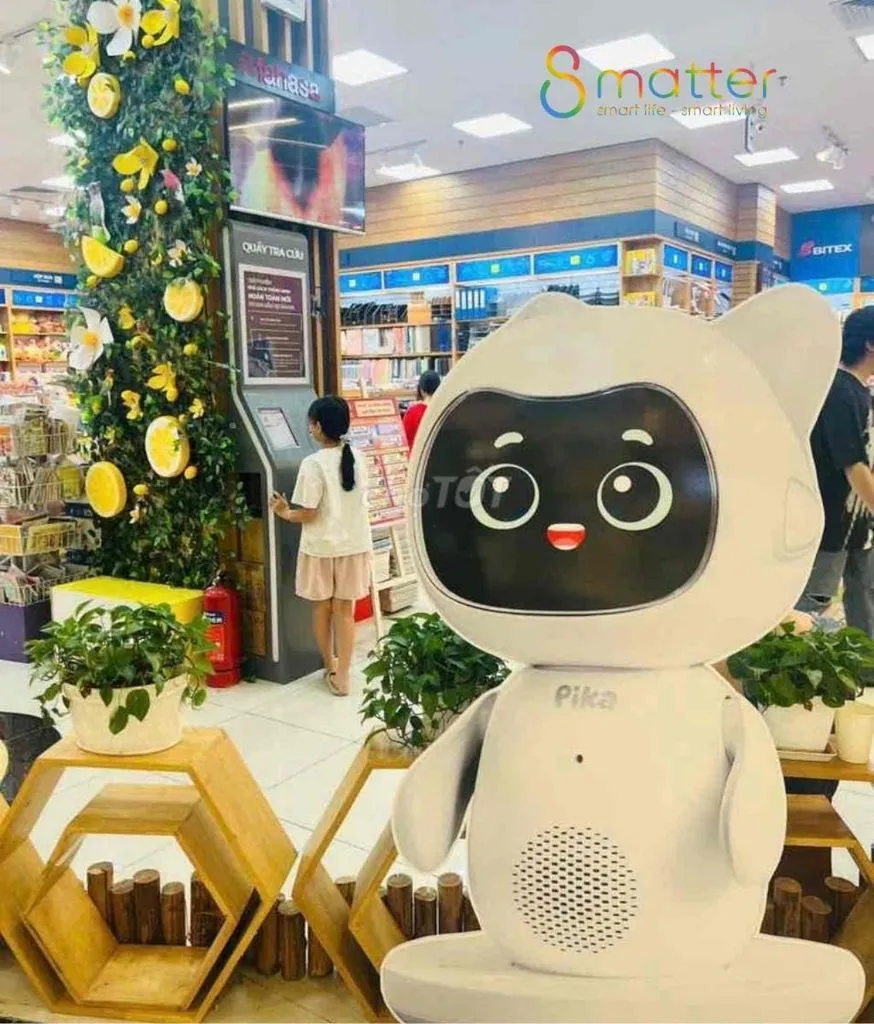 Robot Pika đội mũ len đặt trên bục, phía sau là cây thông trang trí