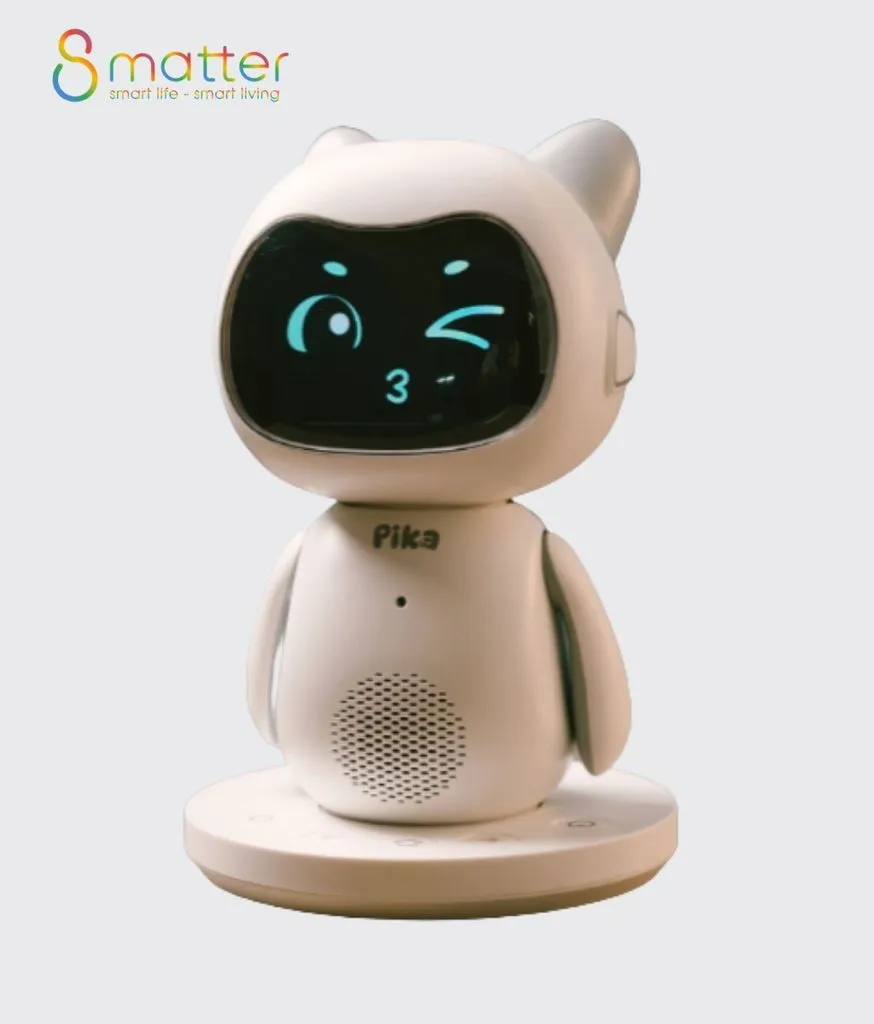 Robot Pika trắng đứng trên đế sạc tròn, màn hình mặt hiển thị biểu cảm nháy mắt