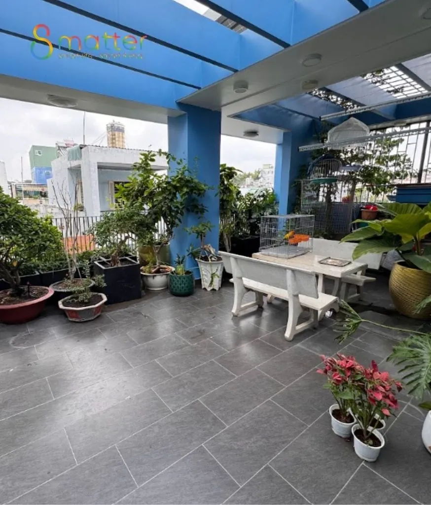 Khoảng sân thượng rộng có bộ bàn ghế và vài chậu cây cảnh