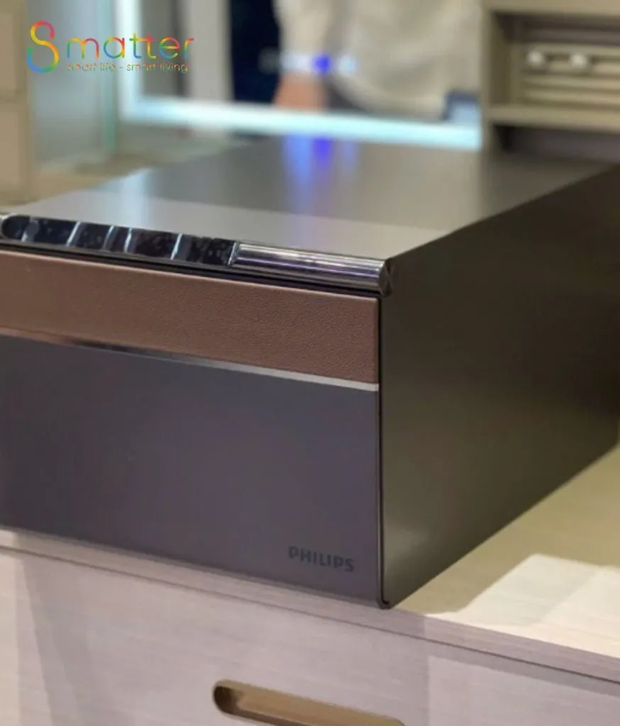 Cận cảnh mặt trên két Philips có dải đèn xanh, đặt bên trong ngăn tủ gỗ