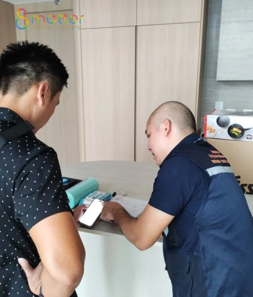 Hai người đàn ông bên bàn bếp trắng, kỹ thuật viên đang thao tác điện thoại