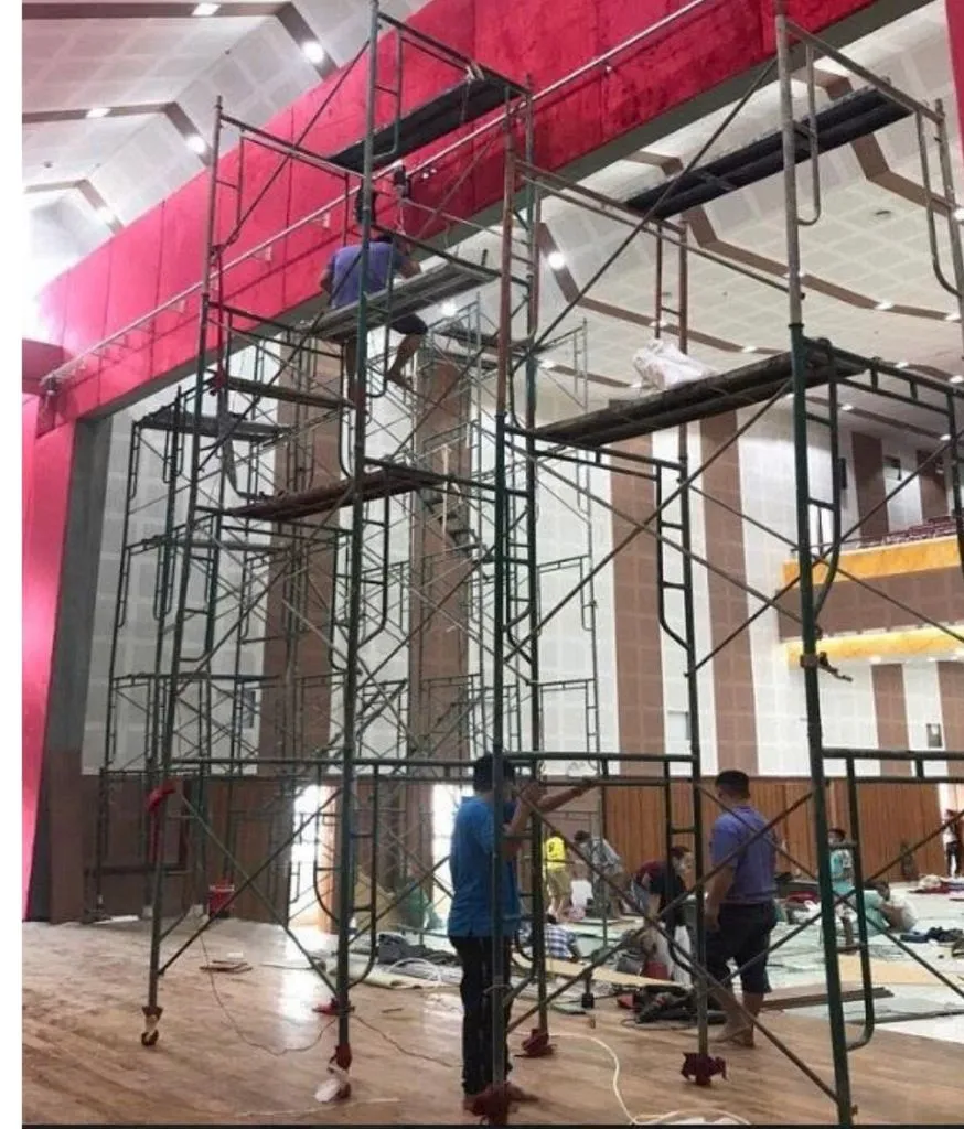 Công nhân dựng giàn giáo thi công trong hội trường tường đỏ lớn