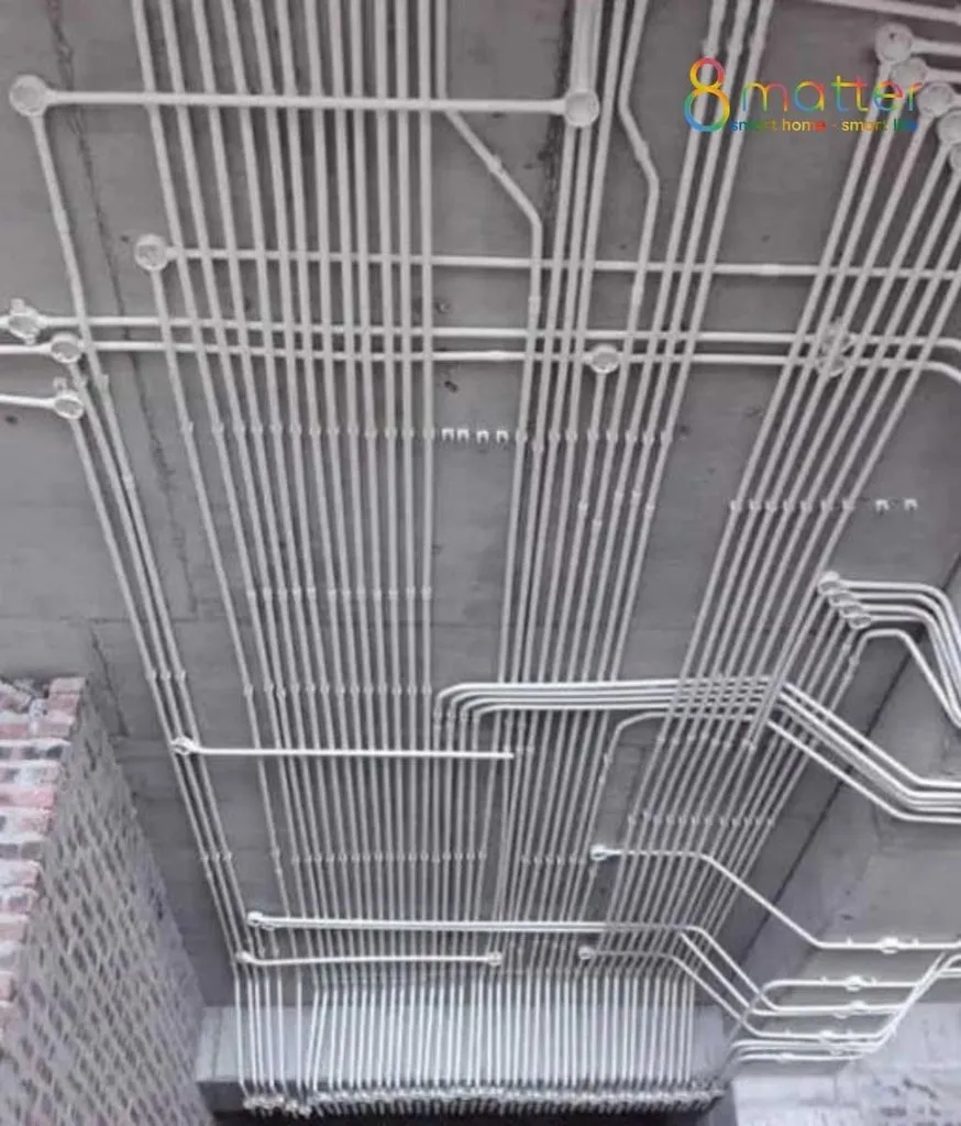 Trần bê tông với hệ ống điện đi nổi màu trắng xếp thành nhiều hàng trong công trình
