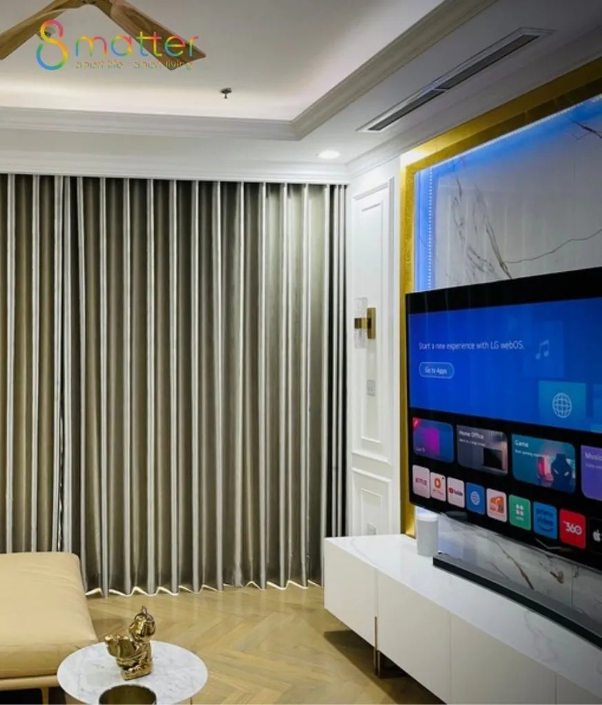 Phòng khách rèm xám dài, TV LG lớn treo tường ốp đá