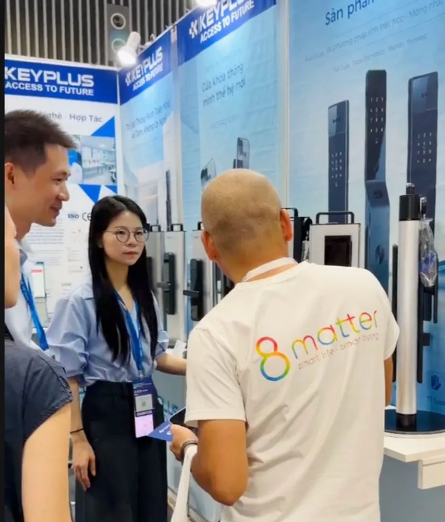 Người áo 8matter trao đổi với hai nhân viên tại gian hàng khoá KEYPLUS