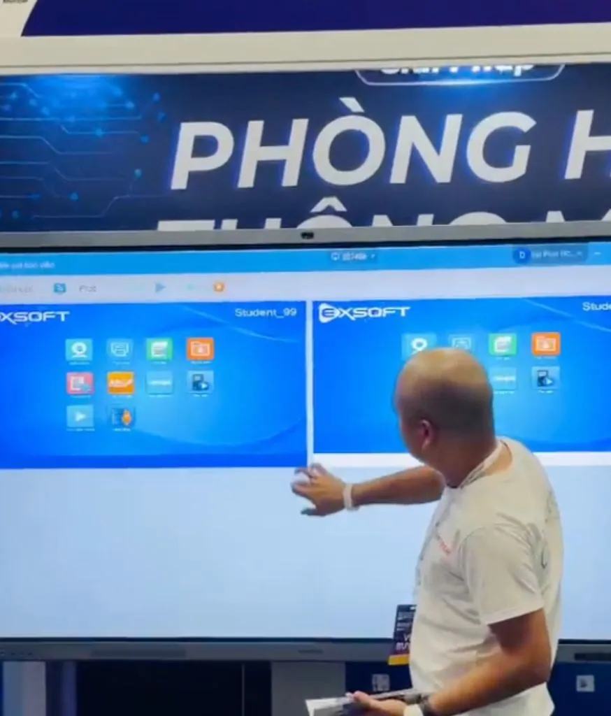 Người đàn ông thuyết trình chỉ vào màn hình lớn trong gian hàng triển lãm